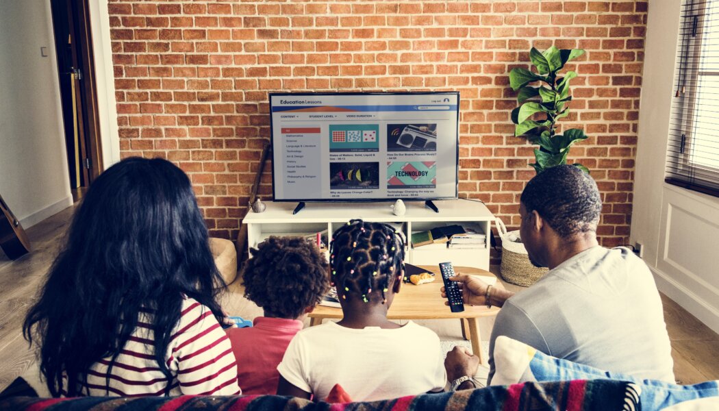 Family of 4 watching TV together